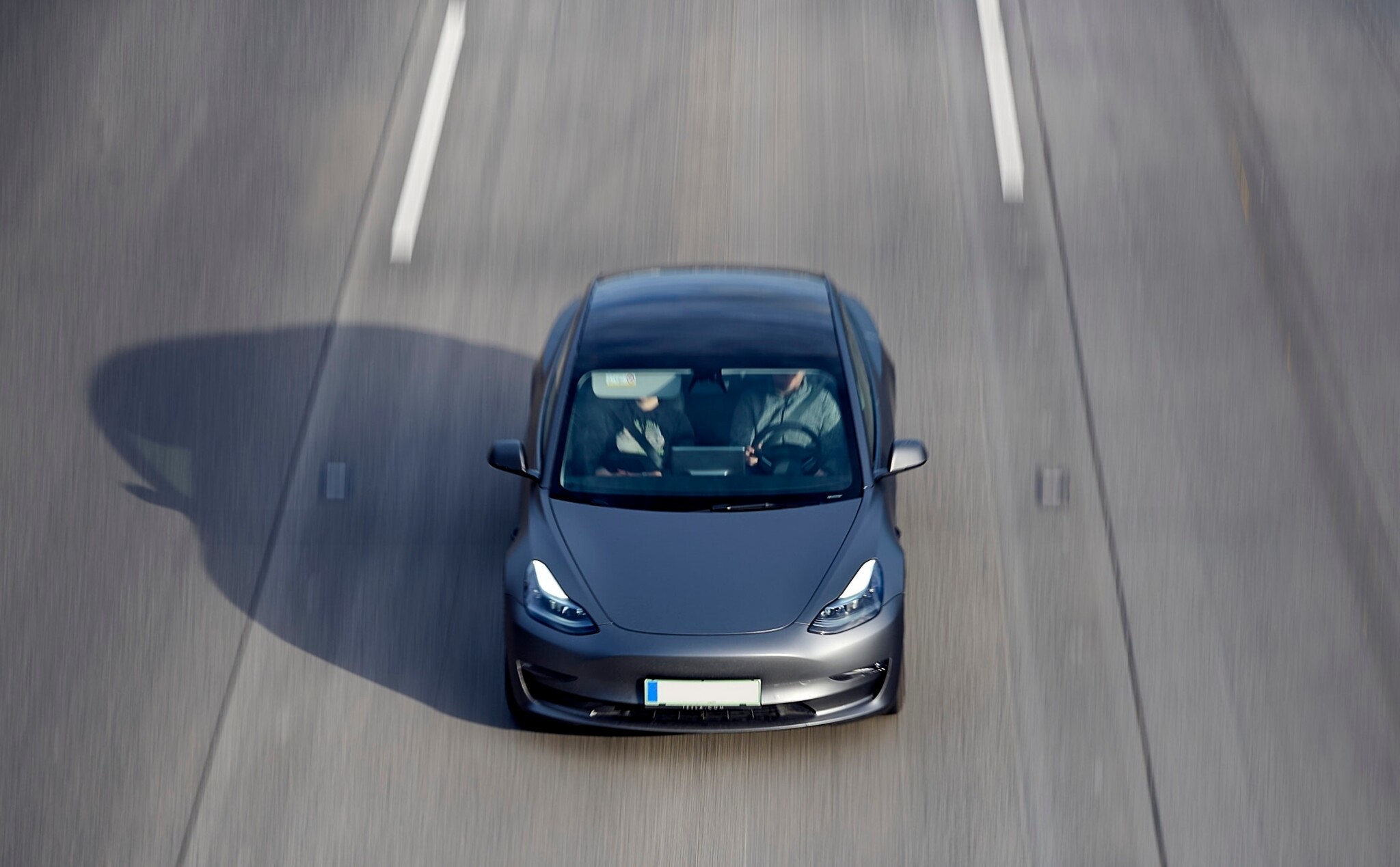 Tesla driving fast down a highway